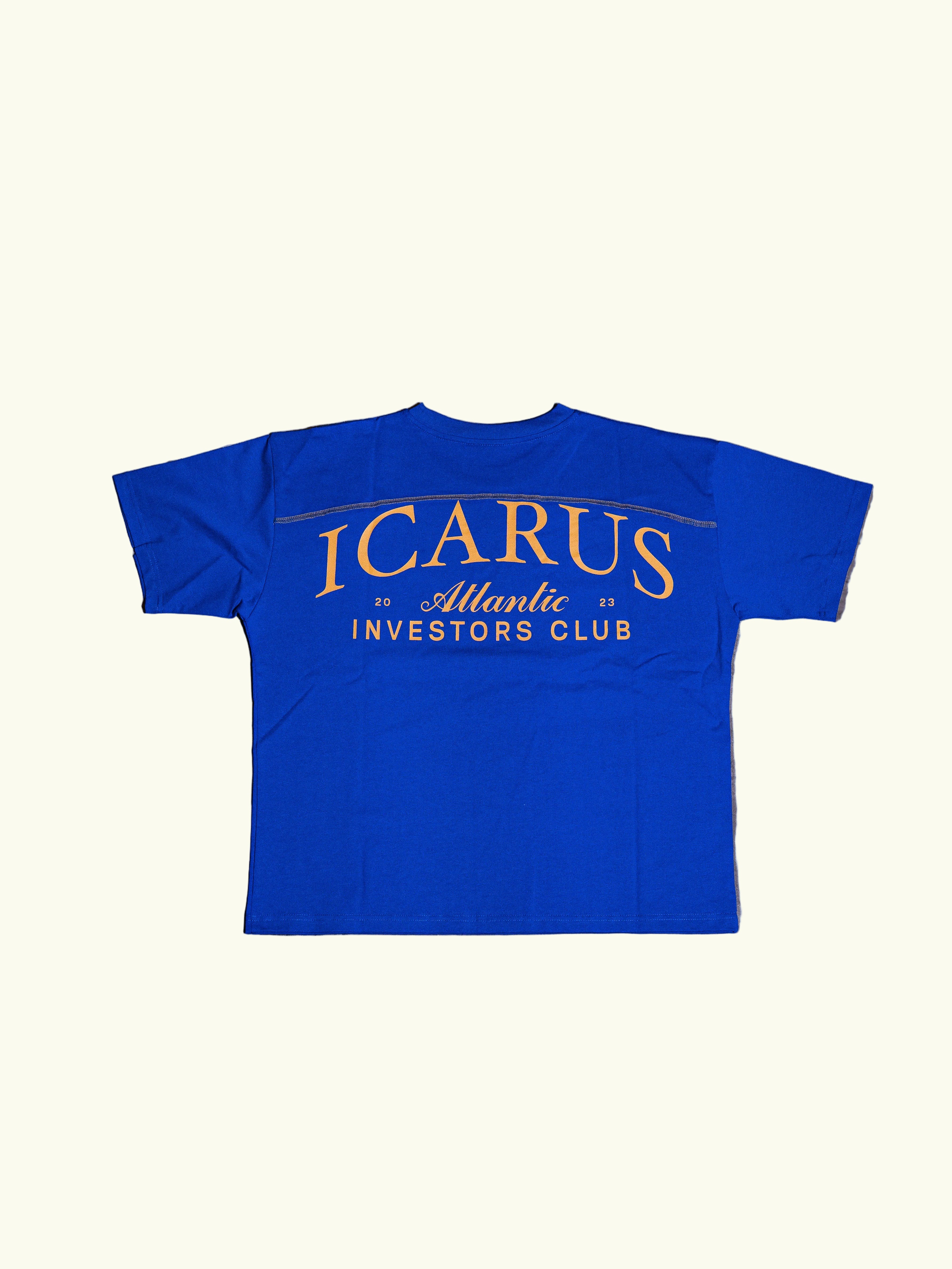 Blue t-shirt with 'Icarus Atlantic Investors Club' text on a concrete floor.